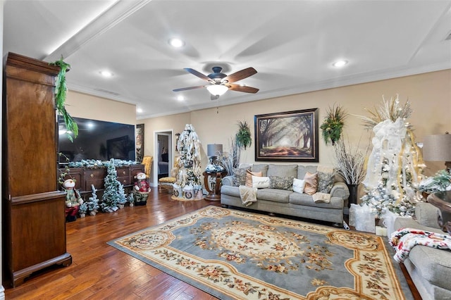 living room with dark hardwood / wood-style flooring, ceiling fan, and crown molding