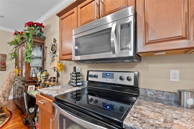 kitchen featuring light stone countertops, black range with electric cooktop, hardwood / wood-style flooring, and ornamental molding