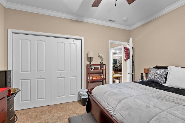 bedroom featuring ceiling fan, a closet, light carpet, and ornamental molding