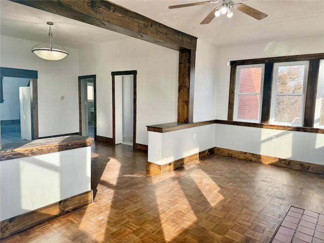 interior space with baseboards, beam ceiling, and a ceiling fan