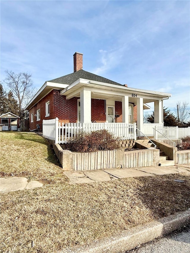 view of front of property with a porch and a front lawn