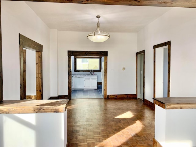 hall featuring baseboards and a sink