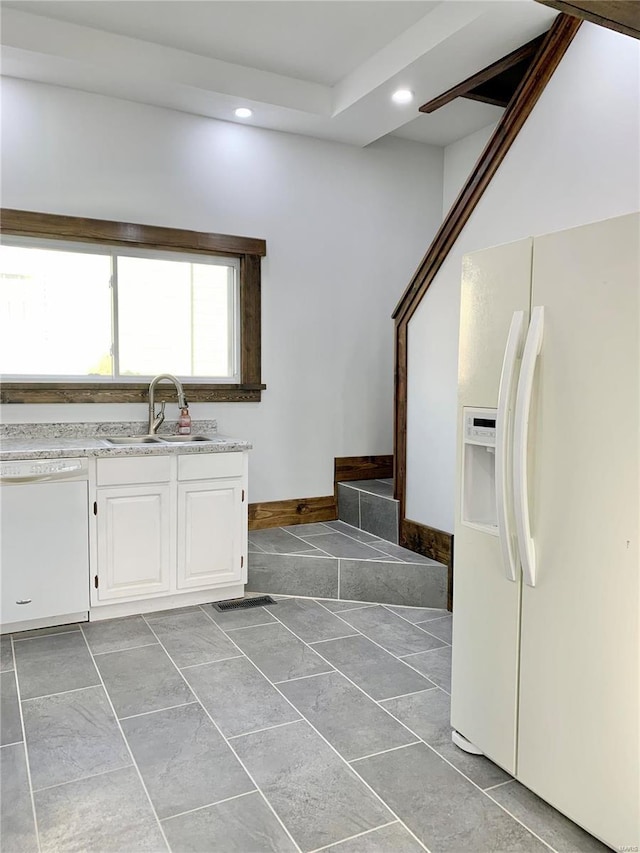 kitchen with light countertops, recessed lighting, white appliances, white cabinetry, and a sink