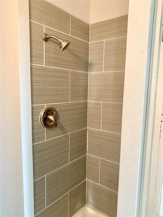 interior details with a tile shower