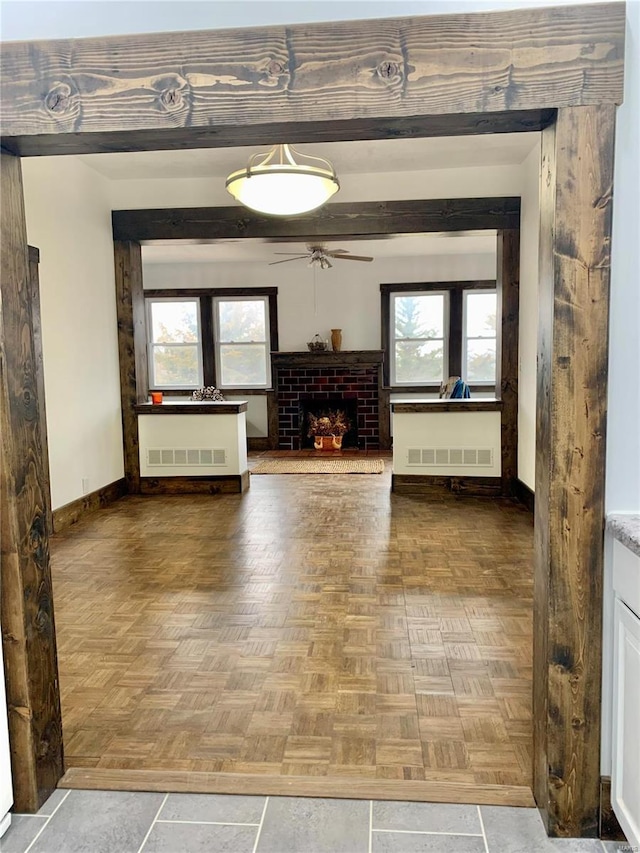 unfurnished living room with plenty of natural light, a fireplace, visible vents, and baseboards