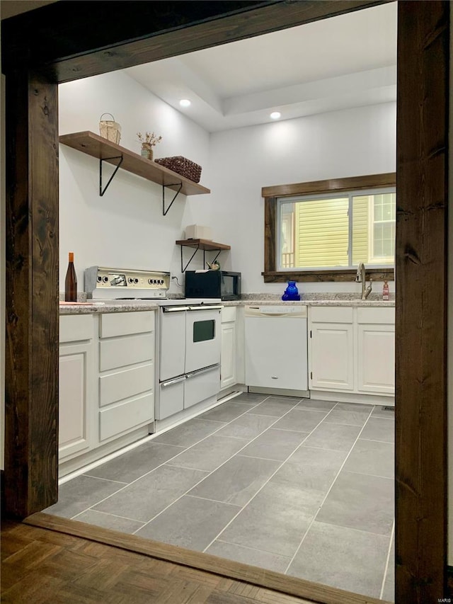 kitchen with light stone counters, recessed lighting, white appliances, white cabinetry, and open shelves