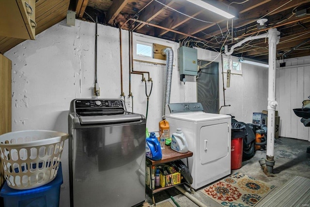 clothes washing area with washer and dryer, electric panel, and a healthy amount of sunlight