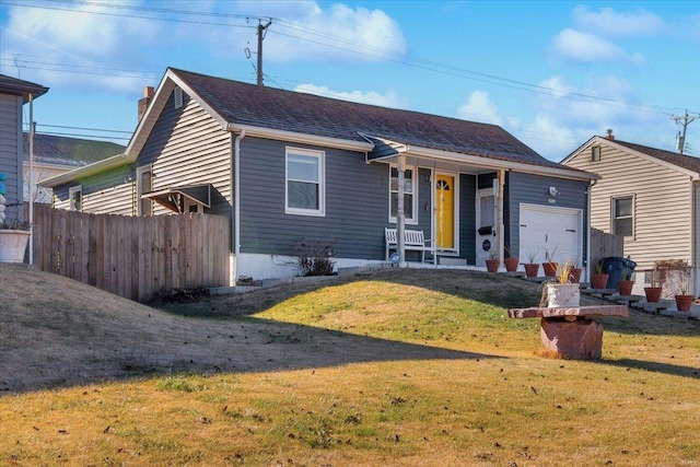 view of front of property with covered porch, a garage, and a front yard