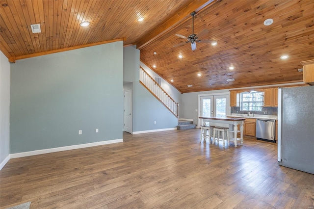 kitchen with stainless steel appliances, ceiling fan, lofted ceiling with beams, wooden ceiling, and hardwood / wood-style floors