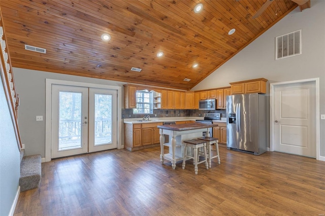 kitchen featuring wooden ceiling, a kitchen breakfast bar, light hardwood / wood-style flooring, a kitchen island, and appliances with stainless steel finishes