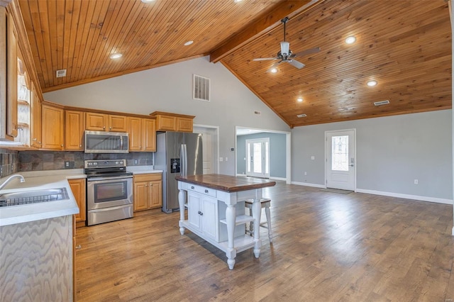 kitchen featuring wooden counters, a center island, stainless steel appliances, and light hardwood / wood-style floors