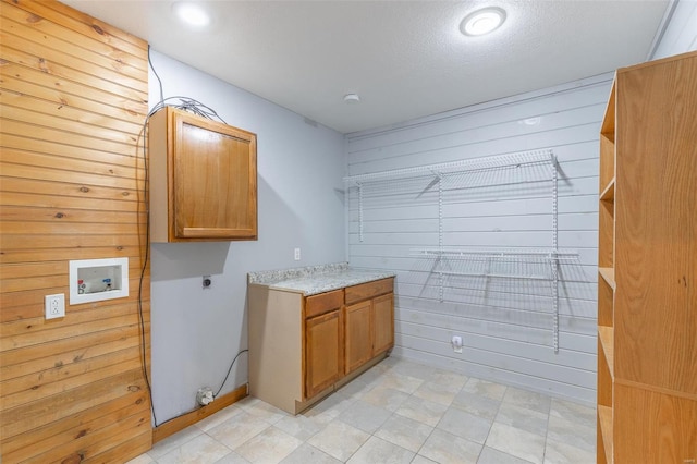 laundry room with wooden walls, hookup for a washing machine, cabinets, and hookup for an electric dryer