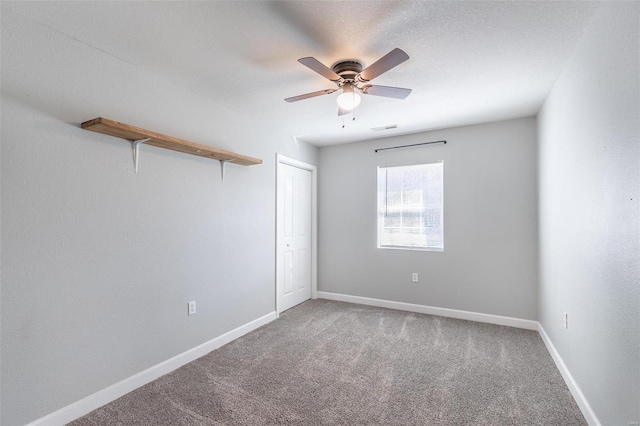 unfurnished room featuring ceiling fan and carpet floors