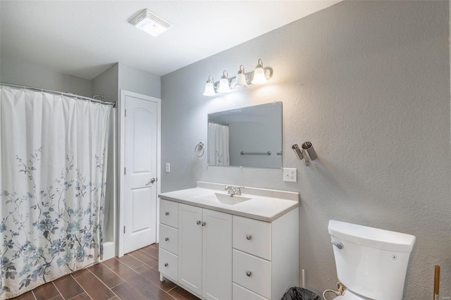 bathroom featuring vanity, hardwood / wood-style flooring, toilet, and curtained shower