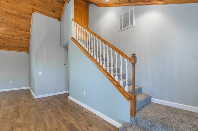 stairs with wood ceiling, lofted ceiling, and wood-type flooring