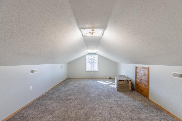 additional living space featuring carpet flooring, lofted ceiling, and a textured ceiling