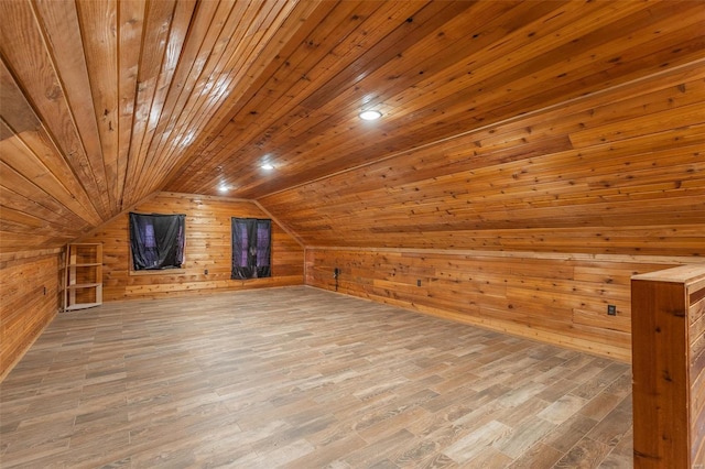 additional living space featuring hardwood / wood-style floors, lofted ceiling, wood walls, and wood ceiling