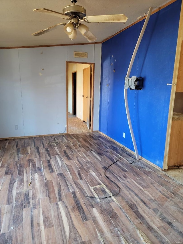 interior space featuring ceiling fan, wood-type flooring, and ornamental molding