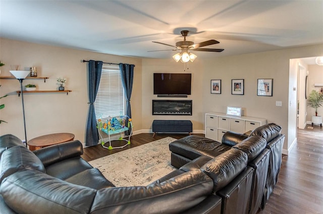 living room with ceiling fan and dark wood-type flooring