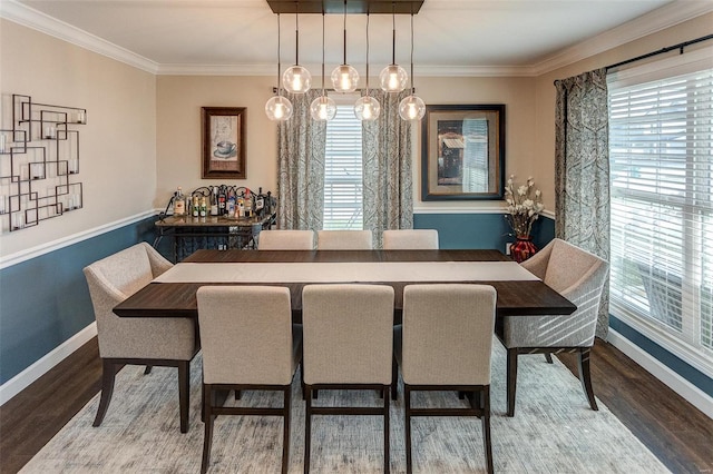 dining space with crown molding, plenty of natural light, and hardwood / wood-style flooring