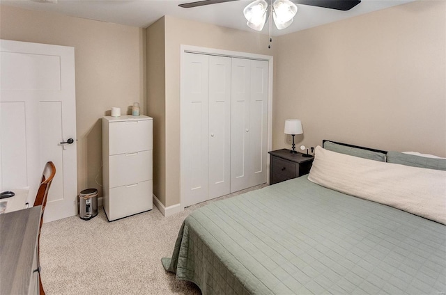 carpeted bedroom featuring ceiling fan and a closet