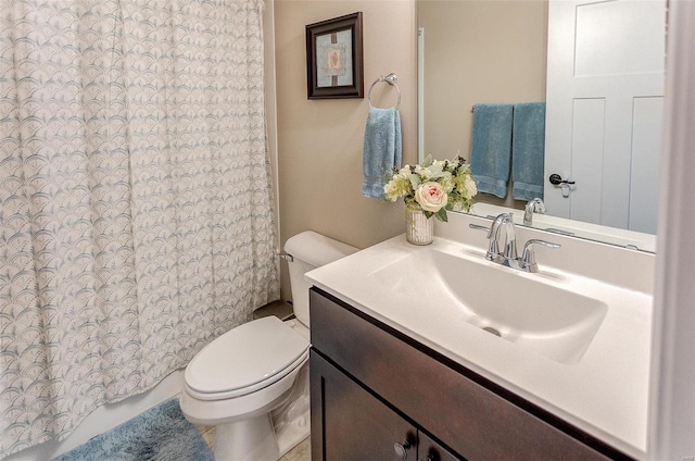 bathroom featuring curtained shower, vanity, and toilet