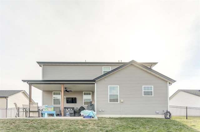 rear view of property featuring a patio, ceiling fan, and a lawn