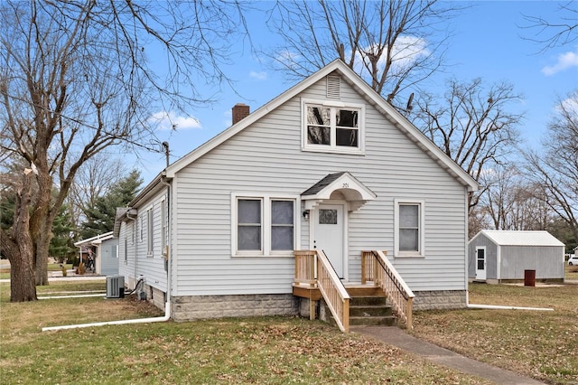 bungalow-style house featuring a front lawn and cooling unit