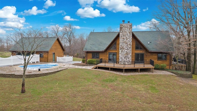 back of house with a swimming pool side deck and a yard