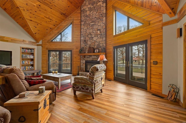 living room with french doors, high vaulted ceiling, plenty of natural light, and light hardwood / wood-style flooring