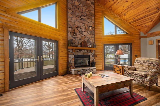 living room with wooden ceiling, light hardwood / wood-style flooring, high vaulted ceiling, and a healthy amount of sunlight