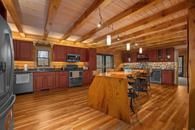 kitchen with a healthy amount of sunlight, beverage cooler, sink, and appliances with stainless steel finishes