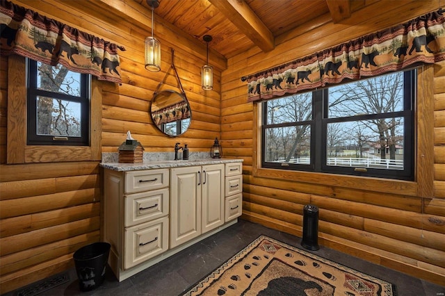 interior space featuring beam ceiling, rustic walls, and plenty of natural light