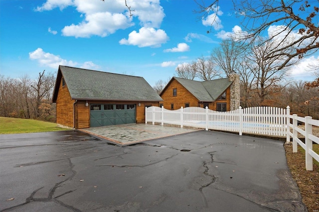 exterior space featuring a garage and an outbuilding