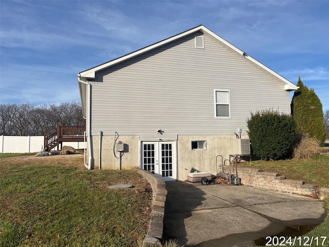 back of property featuring a yard, a wooden deck, and french doors