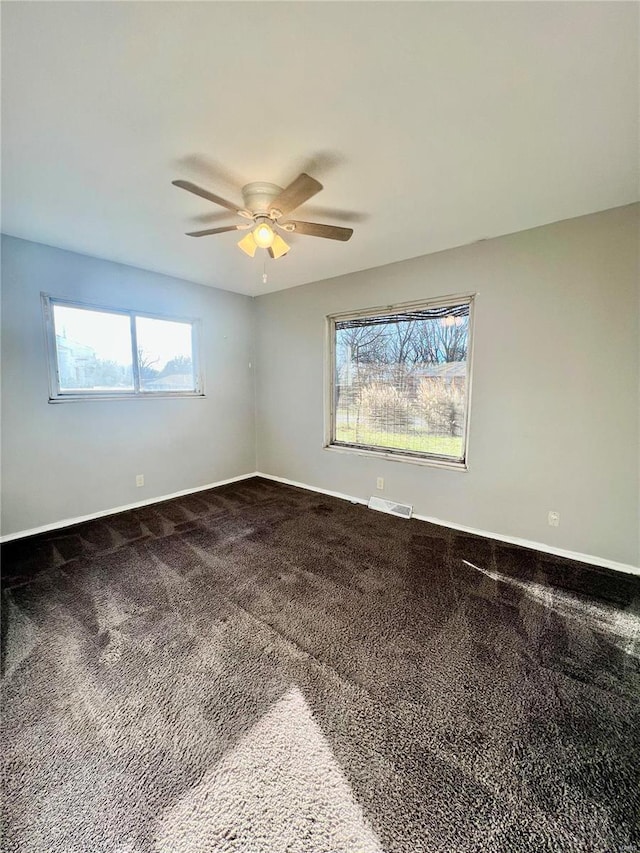 spare room featuring ceiling fan, plenty of natural light, and carpet floors