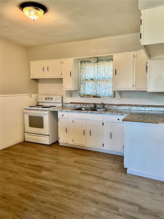 kitchen with light hardwood / wood-style flooring, white cabinetry, white electric stove, and sink