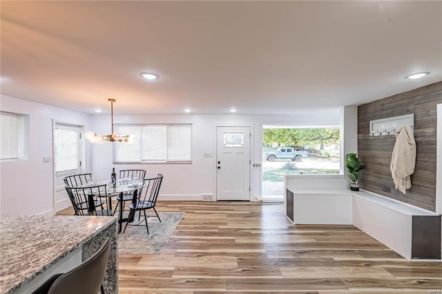 dining room with a wealth of natural light, a chandelier, and light wood-type flooring