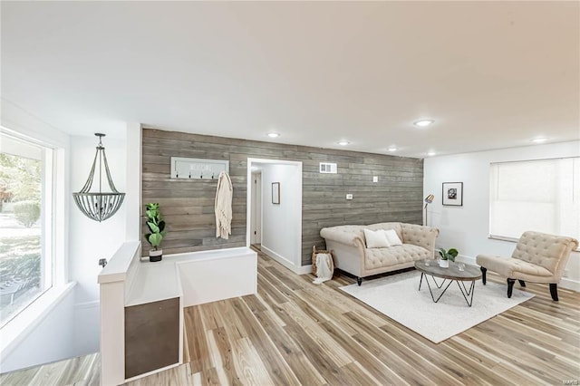 living room featuring wooden walls and light hardwood / wood-style floors