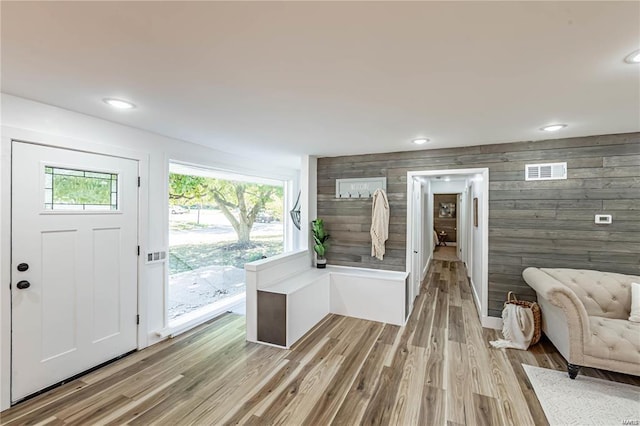 foyer entrance featuring wood walls and light wood-type flooring