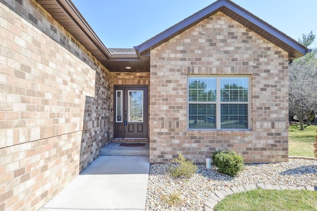 view of exterior entry featuring brick siding