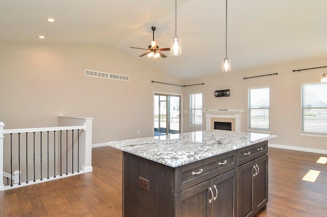 kitchen featuring a wealth of natural light, visible vents, dark brown cabinetry, and open floor plan