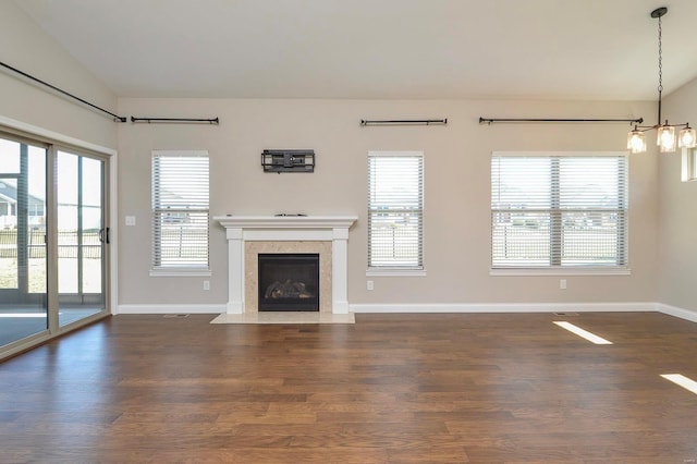 unfurnished living room with baseboards, a fireplace with flush hearth, and dark wood-style flooring