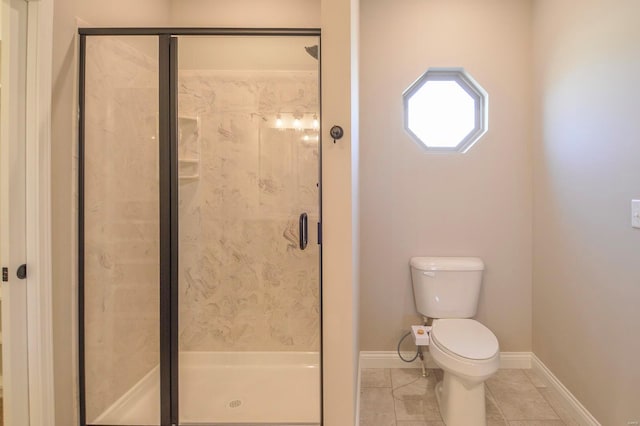 bathroom with baseboards, toilet, a stall shower, and tile patterned flooring