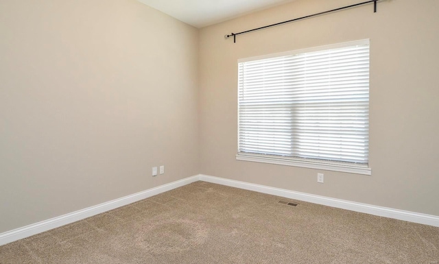 unfurnished room with baseboards, visible vents, and light carpet