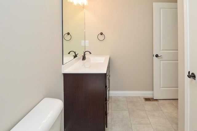 bathroom with vanity, baseboards, visible vents, tile patterned floors, and toilet