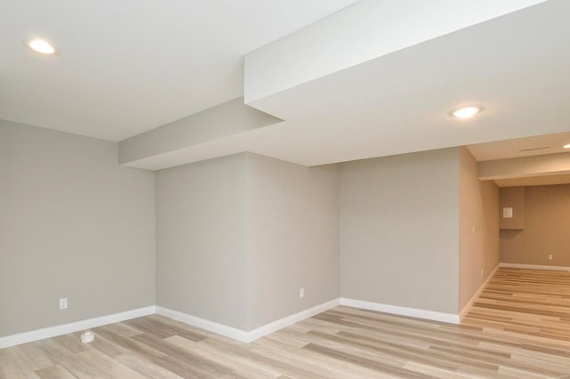 finished basement with recessed lighting, light wood-type flooring, and baseboards