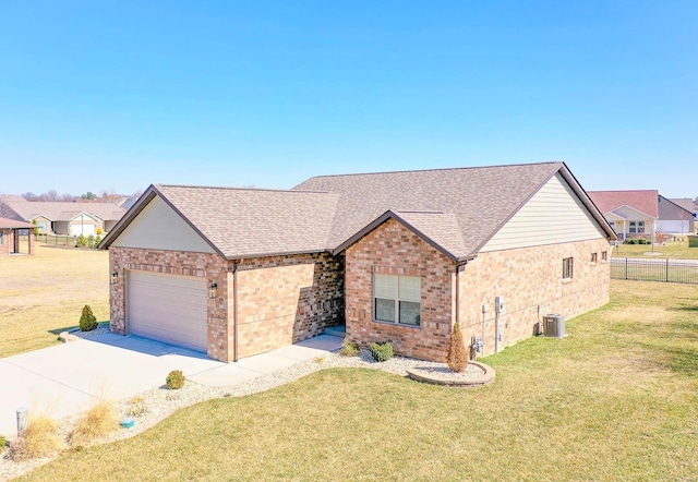 ranch-style home featuring a shingled roof, fence, central AC, a front yard, and a garage