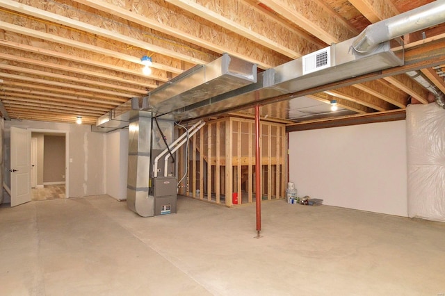 unfinished basement with heating unit and visible vents