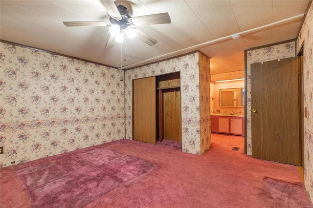 unfurnished bedroom with carpet, a textured ceiling, ensuite bath, and ceiling fan